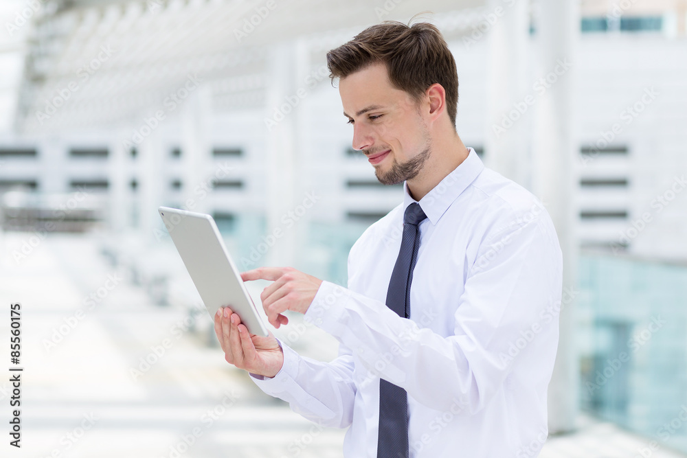Caucasian businessman touch on digital tablet at outdoor Caucasian businessman touch on digital tablet at outdoor