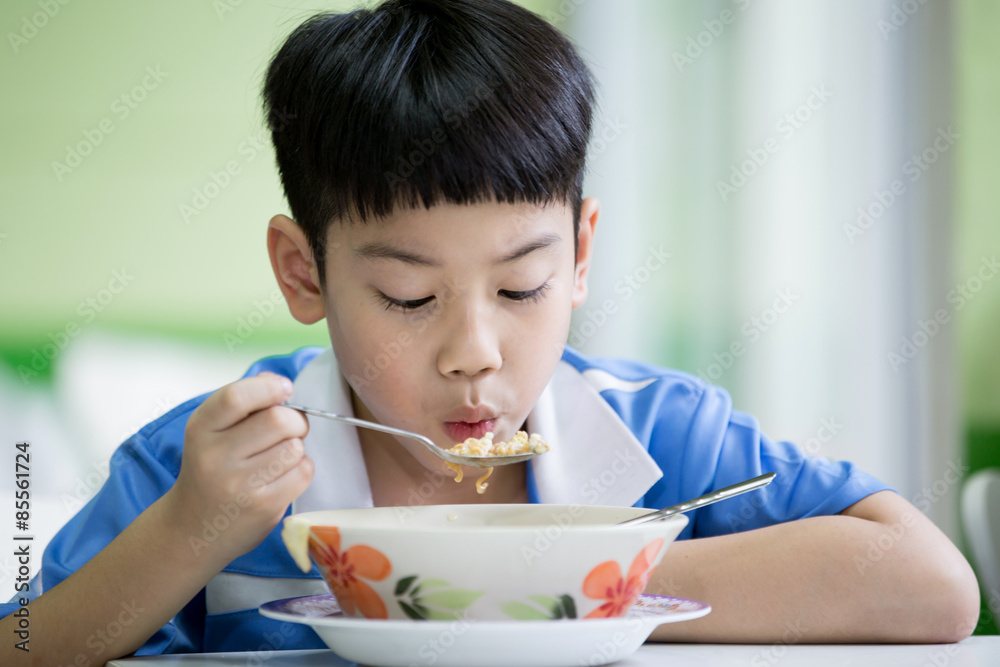 Young Chinese Boy Sitting At Home Eating Meal Young Chinese Boy Sitting At Home Eating Meal