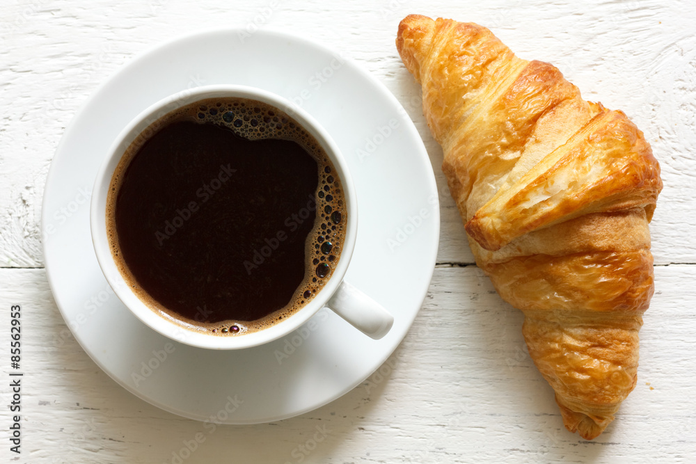 Croissant and coffee on rustic white wood, from above. Croissant and coffee on rustic white wood, from above.