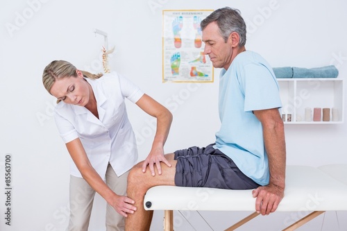 Canvas-taulu Doctor examining her patient knee