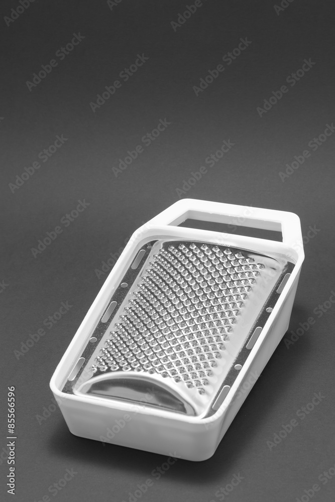 Grater with white plastic lining on a black background Grater with white plastic lining on a black background