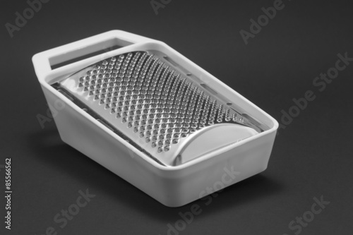 Grater with white plastic lining on a black background photo