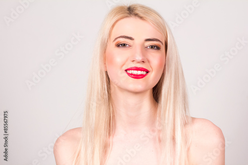 Blonde woman with red lips, make-up and smile with teeth. Beauty concept.