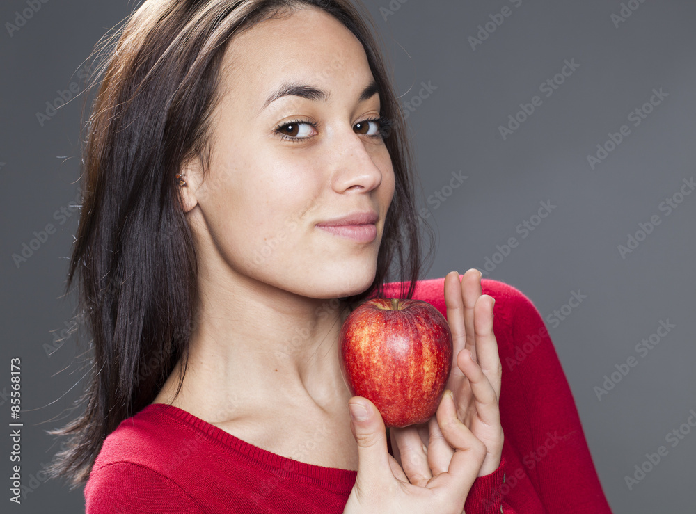 smiling cute young brunette with red sweater proud to hold red apple in hands smiling cute young brunette with red sweater proud to hold red apple in hands