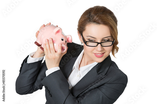 Businesswoman shaking piggybank checking money photo