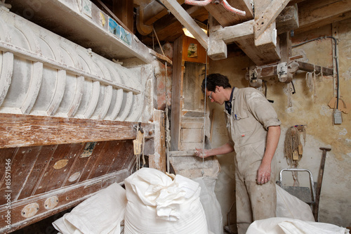 miller looks at the flour in the corn mill