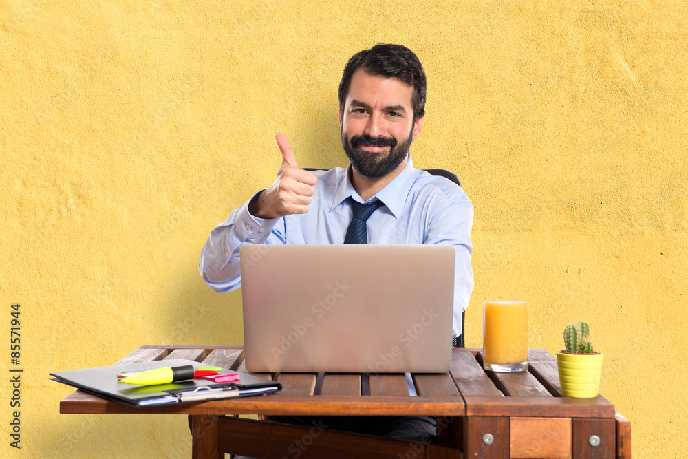 Businessman in his office with thumb up Businessman in his office with thumb up