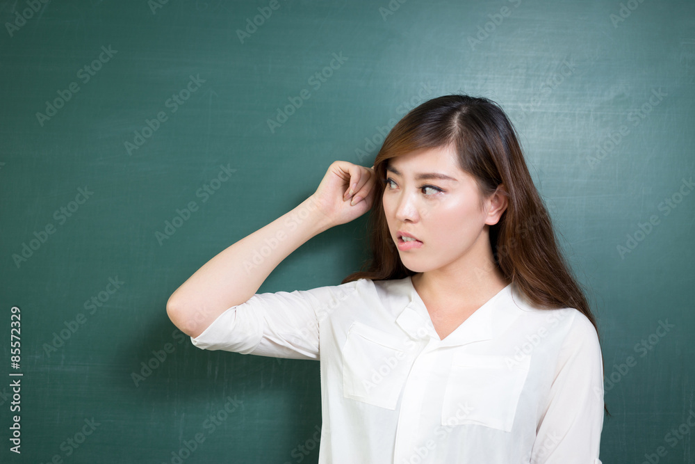 Asian beautiful woman standing in front of blackboard with gesture Asian beautiful woman standing in front of blackboard with gesture