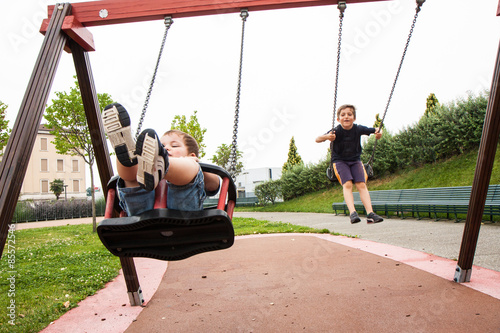 two children playing in the swing