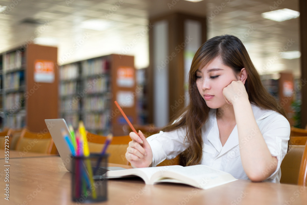 Asian beautiful female student study in library with laptop Asian beautiful female student study in library with laptop
