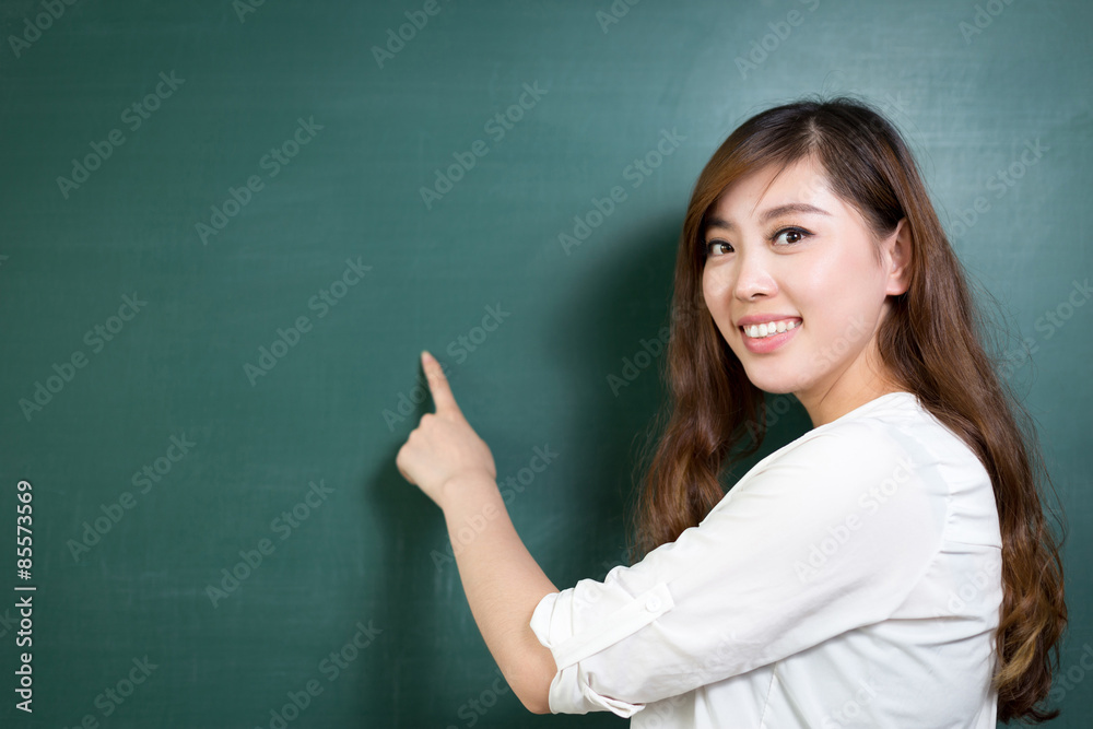 Asian beautiful woman standing in front of blackboard with gesture Asian beautiful woman standing in front of blackboard with gesture