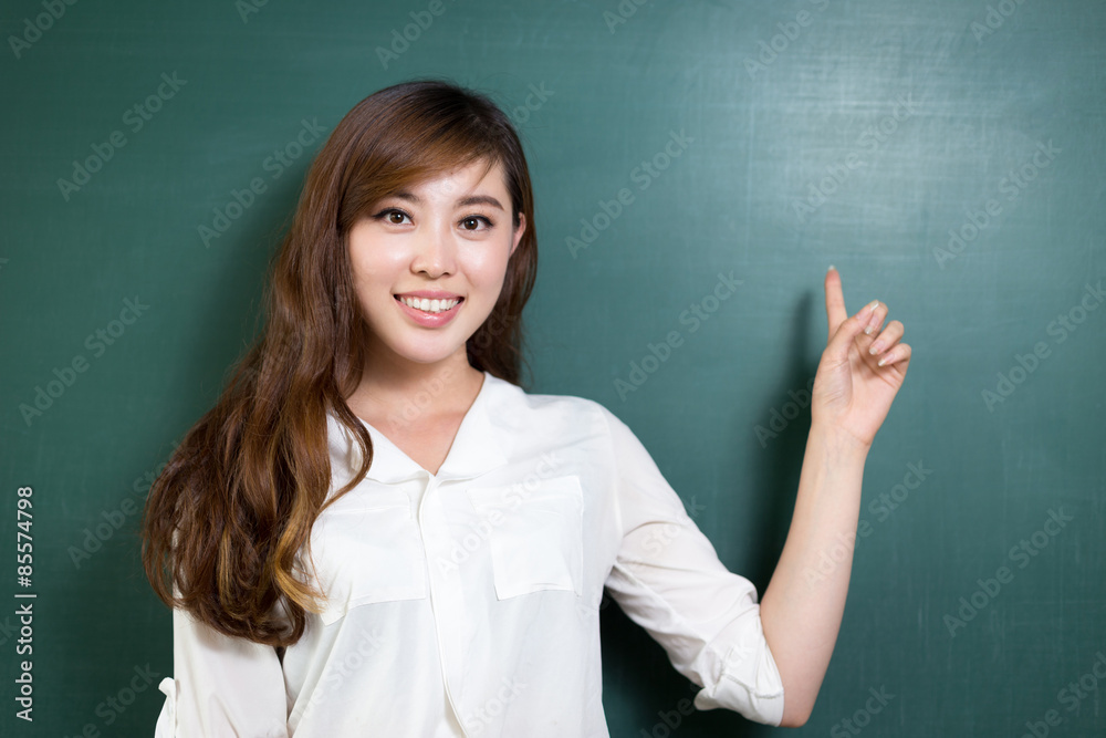 Asian beautiful woman standing in front of blackboard with gesture Asian beautiful woman standing in front of blackboard with gesture
