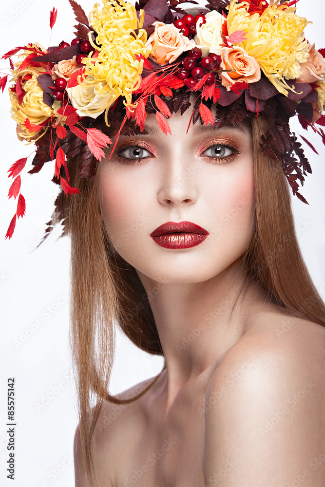 Beautiful red-haired girl with bright autumn wreath of leaves and flowers. Beauty face. Picture taken in the studio on a white background. Beautiful red-haired girl with bright autumn wreath of leaves and flowers. Beauty face. Picture taken in the studio on a white background.