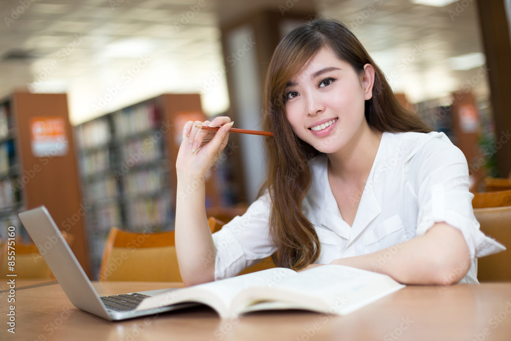 Asian beautiful female student study in library with laptop Asian beautiful female student study in library with laptop