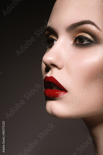 Portrait of beautiful girl with red lips. Picture taken in the studio on a gray background