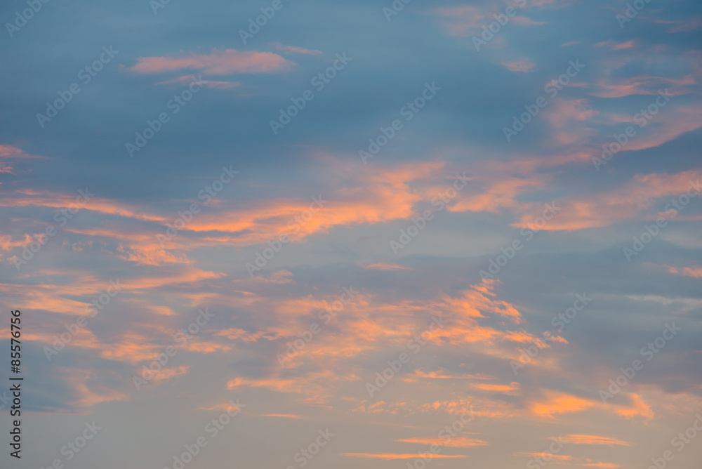 Sunset sky with orange colored clouds.
