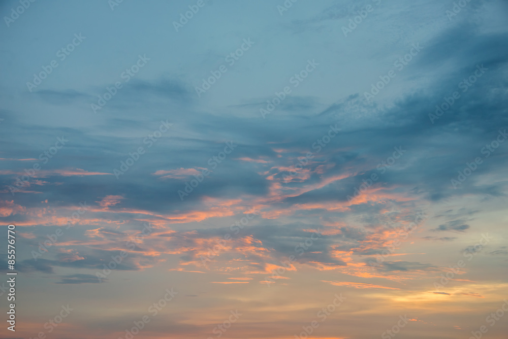 Sunset sky with orange colored clouds.
