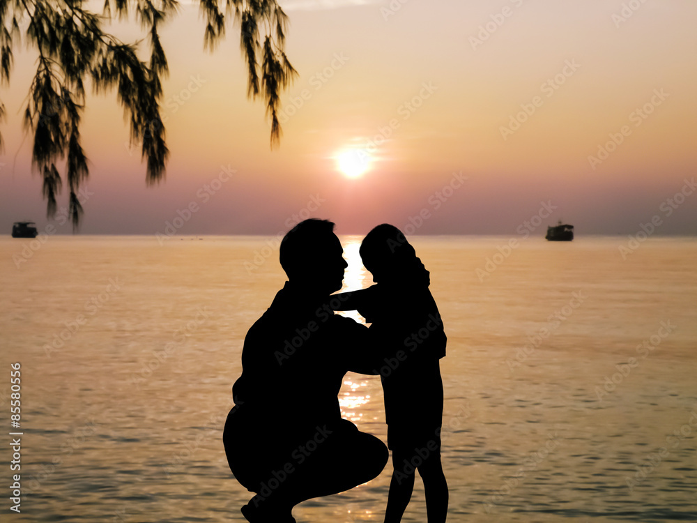 silhouette of father kiss his son at sea  sunrise background