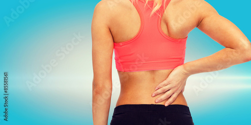 close up of sporty woman touching her back