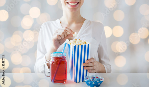 woman eating popcorn with drink in glass mason jar