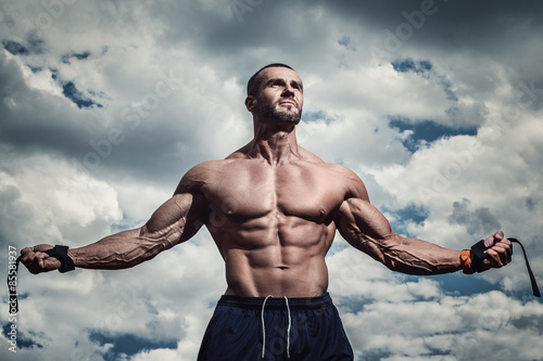Muscular man under cloudy sky photo