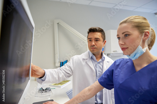 dentists with x-ray on monitor at dental clinic