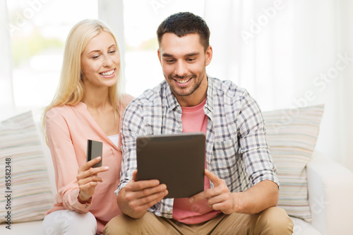 happy couple with tablet pc and credit card