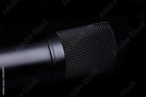 Black microphone on the black background