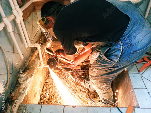 Plumber with angle grinder
