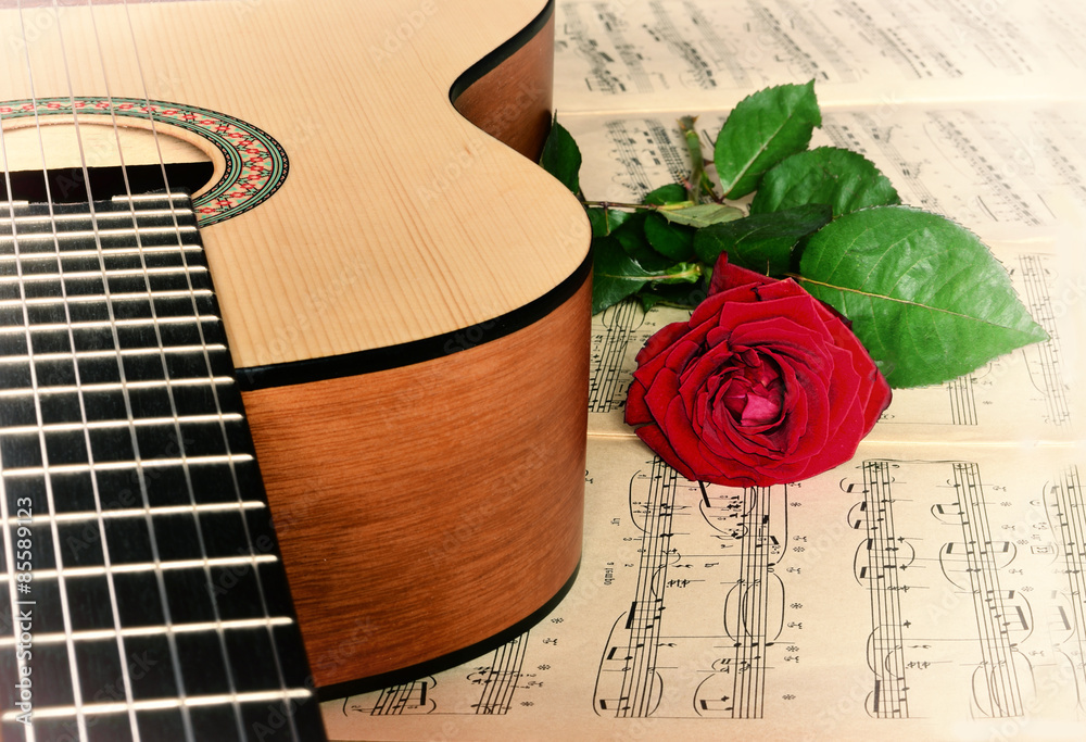 Obraz premium Guitar with classical sheet music and red rose