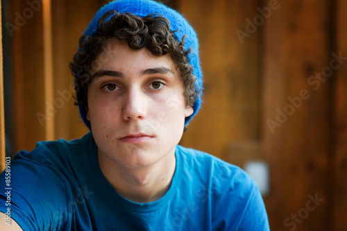 teen boy wearing a hat and looking serious photo