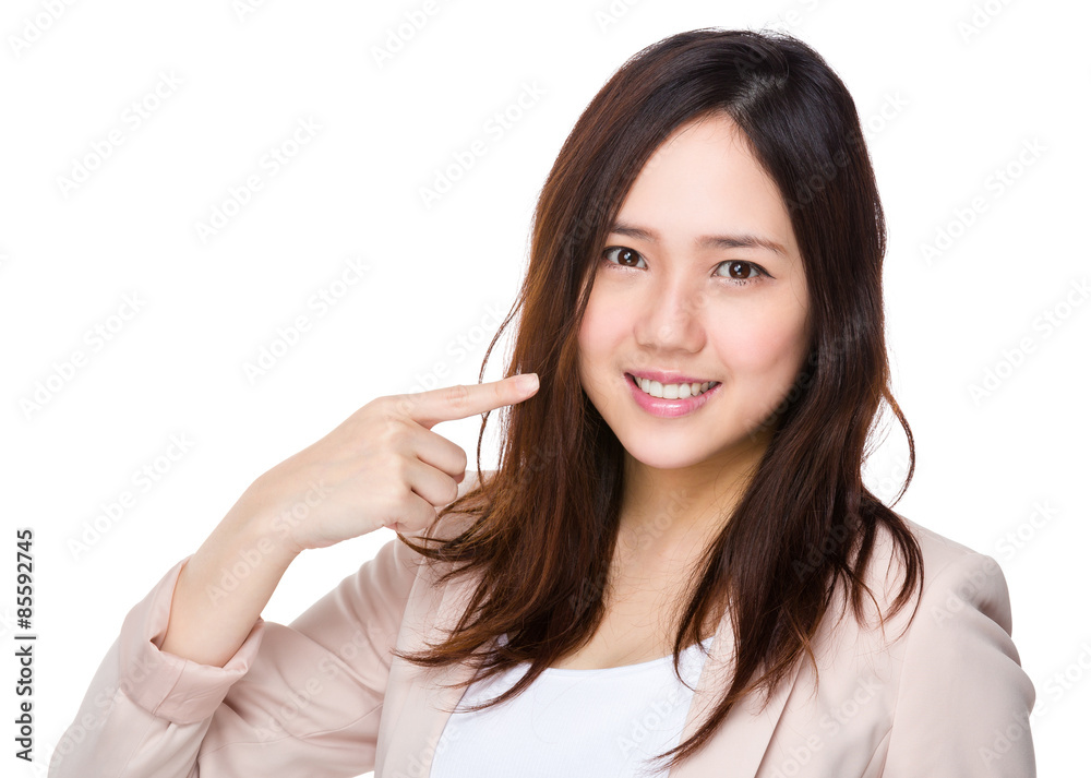 Businesswoman finger point to her teeth, showing toothy smile Businesswoman finger point to her teeth, showing toothy smile