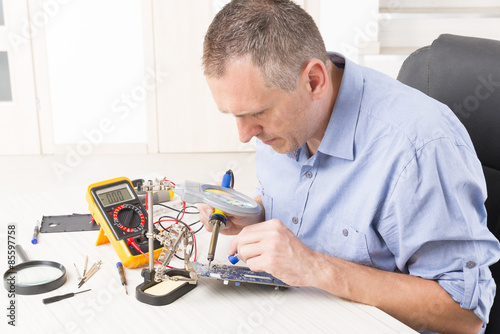 Serviceman soldering on PCB