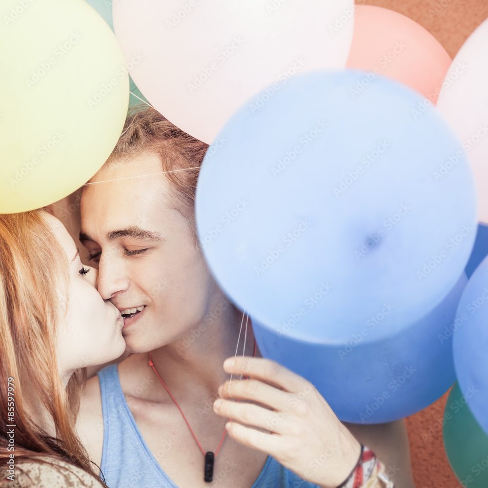 Happy and funny couple kissing at background of color balloons Stock Photo  | Adobe Stock
