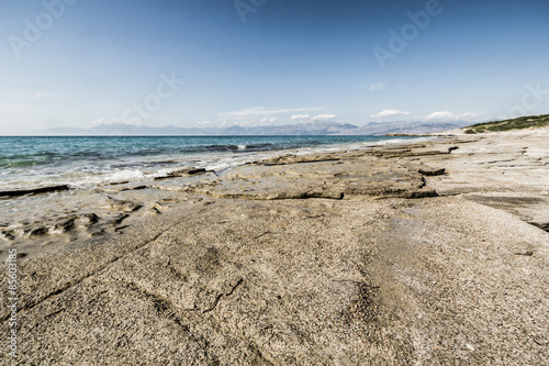 Shore of Ionian sea with flat rocks on the beach