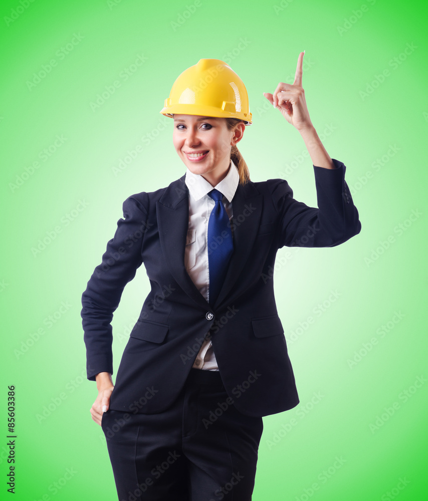 Young businesswoman with hard hat against gradient Young businesswoman with hard hat against gradient