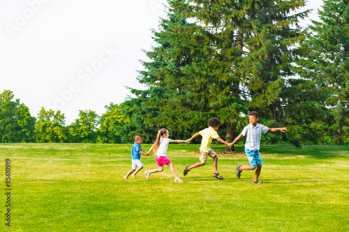 Four children are playing on the glade. © DenisProduction.com