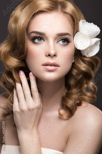 Portrait of a beautiful girl with white flowers on her hair. Beauty face. Photo shot in the Studio on a black background