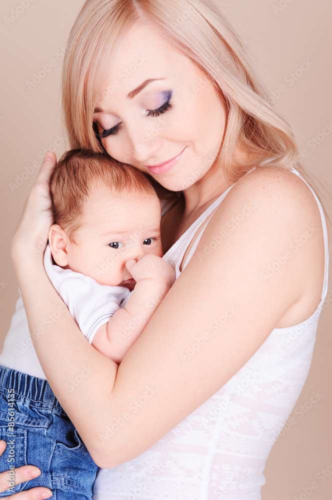 Smiling young woman holding little child. Happy mother with her newborn baby. Motherhood Smiling young woman holding little child. Happy mother with her newborn baby. Motherhood
