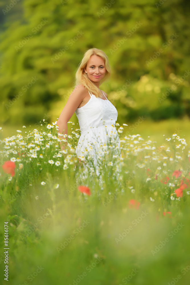 Pregnant happy woman in a flowering poppy field outdoors