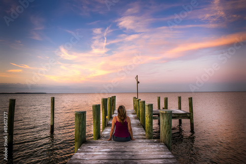 Woman watching a sunset from a pier on the Chesapeake bay in Maryland