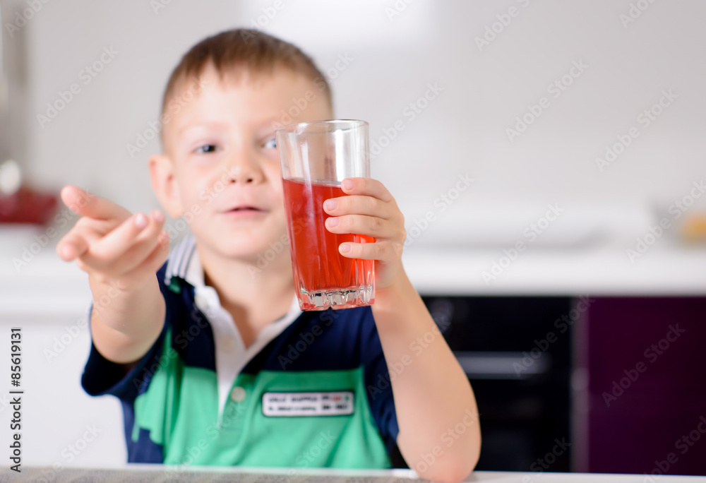 Young Boy Holding Glass of Red Juice Toward Camera Young Boy Holding Glass of Red Juice Toward Camera