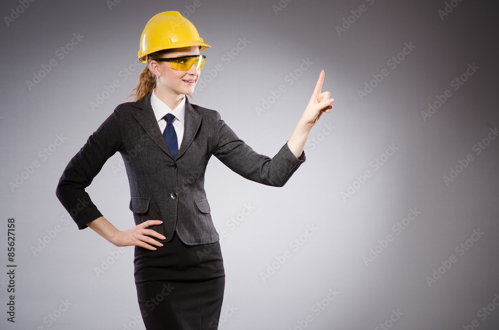 Female engineer with helmet isolated on gray Female engineer with helmet isolated on gray