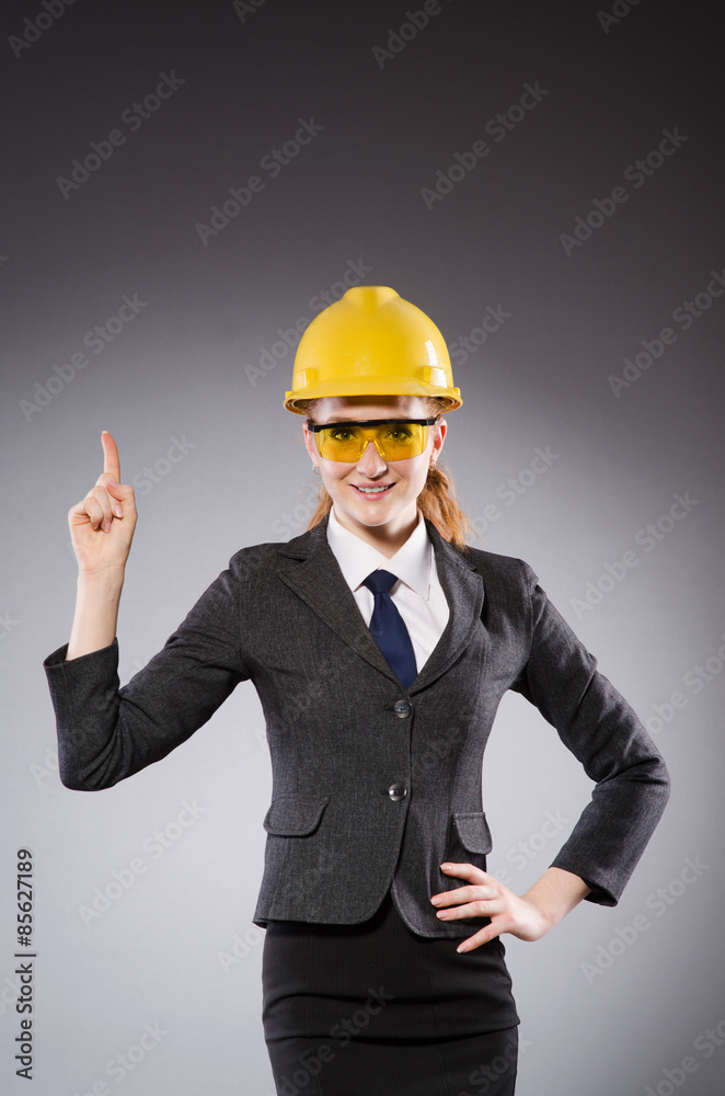 Female engineer with helmet isolated on gray Female engineer with helmet isolated on gray