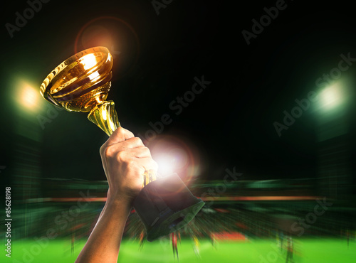 hand rising soccer football championship cup on sport competiton photo