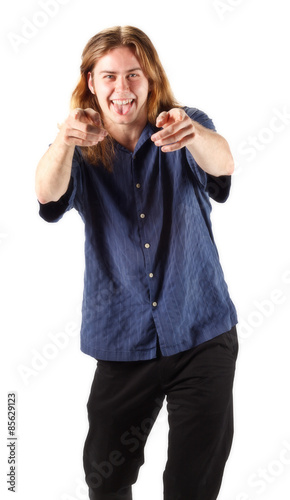 Young happy long haired man smiling and pointing at the camera on a white background