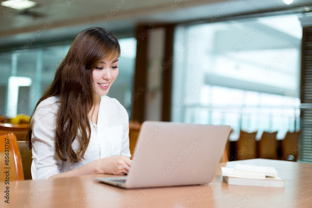 Asian beautiful female student study in library with laptop Asian beautiful female student study in library with laptop