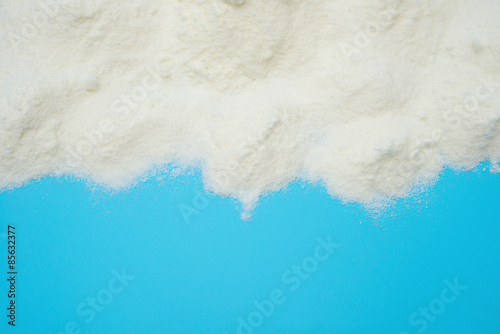 Tableau sur toile powdered milk on blue background with copy space