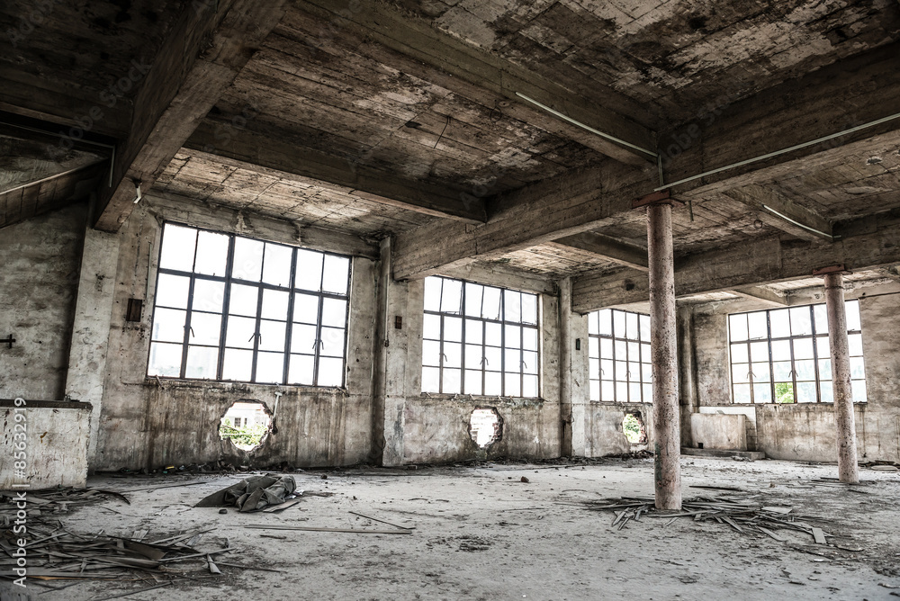 Empty industrial loft in an architectural background with bare cement walls, floors and pillars supporting a mezzanine Empty industrial loft in an architectural background with bare cement walls, floors and pillars supporting a mezzanine