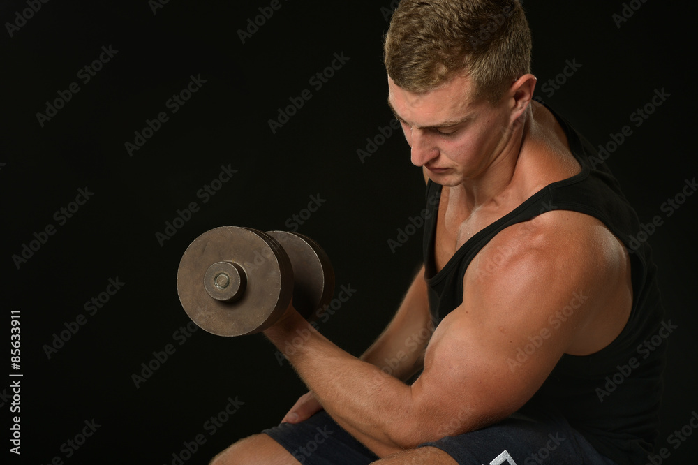 Young man exercises in gym Young man exercises in gym